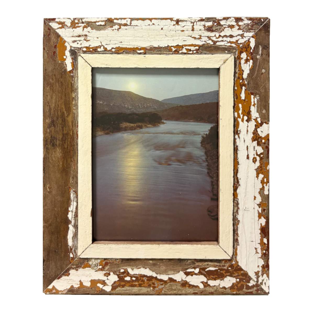 Opera Wabi-Sabi "Oltre l'Ansa": cornice 34×43 cm in legno recuperato con vernice bianca scrostata e passe-partout bianco antico, fotografia a colori di fiume con luce radente e colline rocciose sullo sfondo