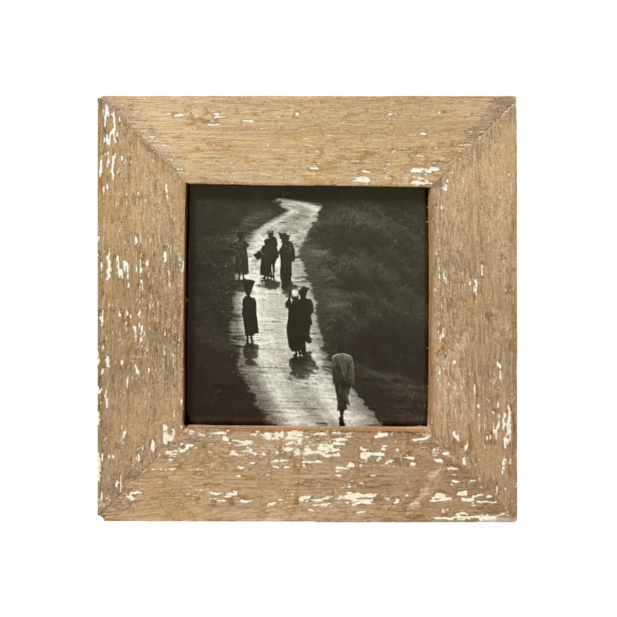 Fotografia bianco e nero in controluce di gruppo di donne su cammino illuminato da sole, dentro cornice legno beige naturale con tracce vernice bianca e venature protagoniste, stile minimalista – 23×23 cm.