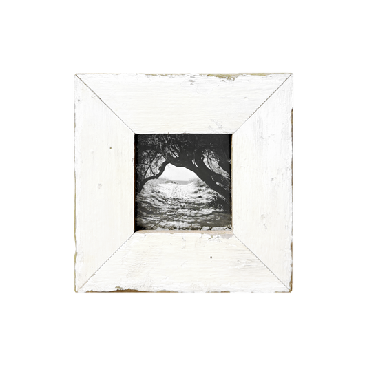 Opera Industrial "La Soglia": cornice quadrata in legno recuperato bianco 18×18 cm, fotografia in bianco e nero di accesso alla spiaggia con arbusti ad arco