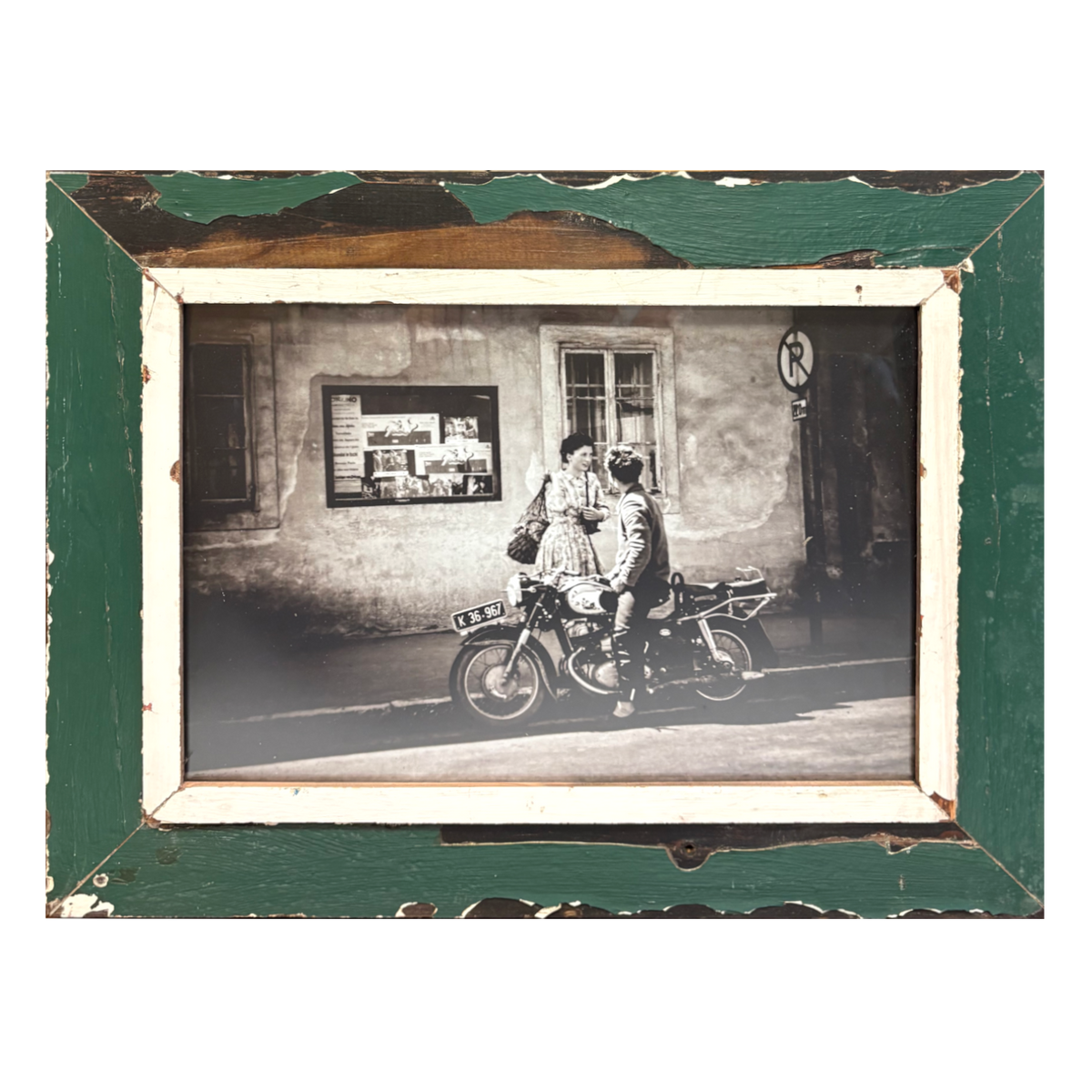 Cornice rettangolare verde imperiale 55×43 cm con passe-partout in legno bianco naturale e vernice erosa sui bordi, contenente fotografia B&W analogica di coppia su motocicletta Ducati/Moto Guzzi anni '80 in strada estiva italiana, lui guarda lei, lei guarda altrove, stile Classico italiano, legno recuperato Cape Town 